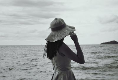 Full length of woman standing on beach against sky