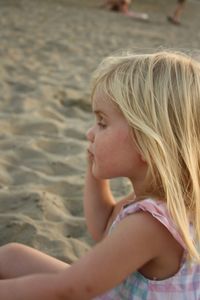 Close-up of girl lying on sand at beach