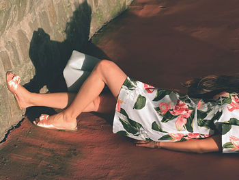 Low section of young woman lying on ground