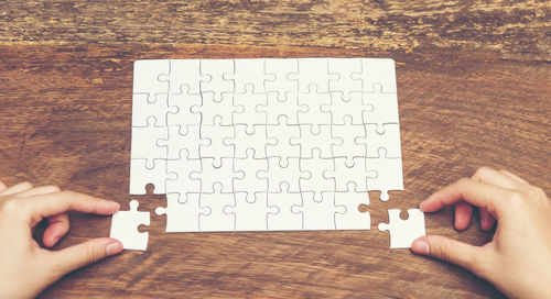 Close-up of person playing jigsaw puzzle on table