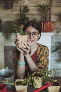 Young woman holding freshly potted cactus