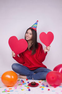 Portrait of woman with heart shaped balloons