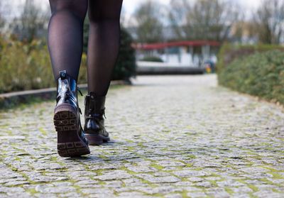 Low section of woman walking on road