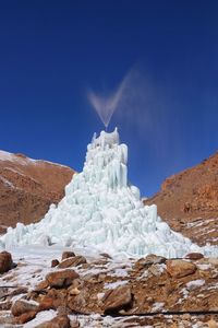 Scenic view of snowcapped mountains against clear blue sky