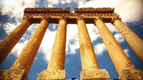 Low angle view of old architectural columns against sky 