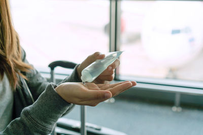 Midsection of man using mobile phone in bus