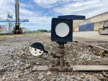 Information sign on railroad track against sky