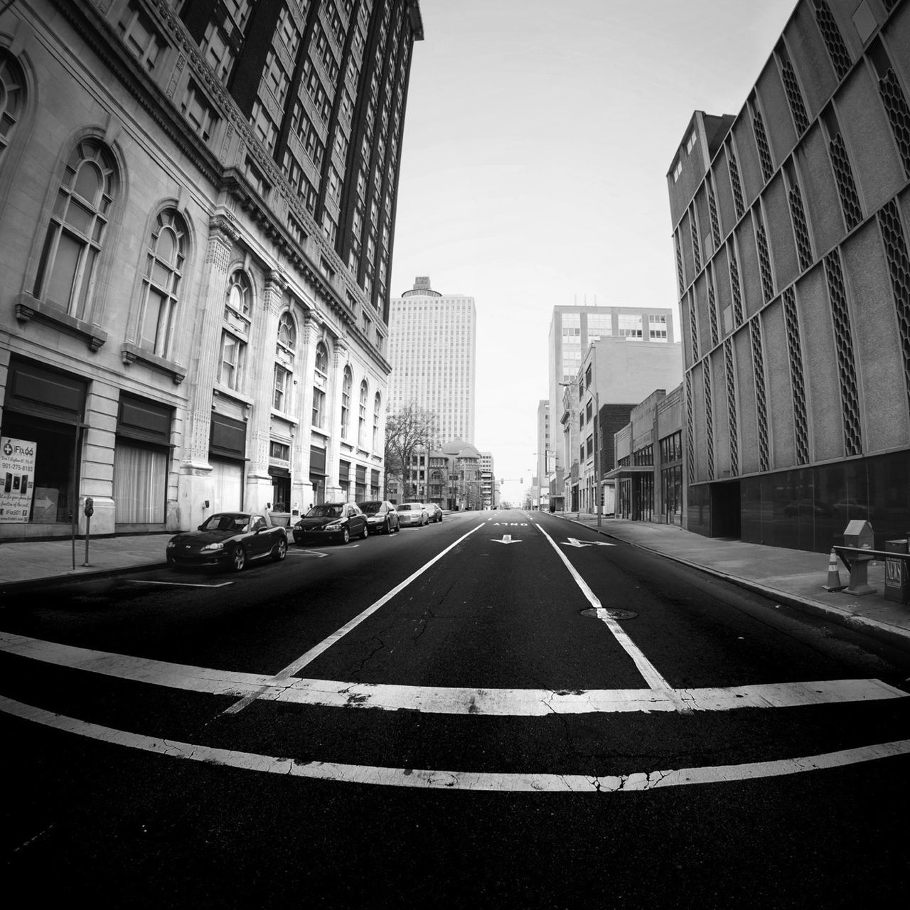 transportation, road marking, architecture, building exterior, built structure, the way forward, road, city, street, diminishing perspective, car, vanishing point, land vehicle, mode of transport, city life, city street, asphalt, incidental people, building, sky