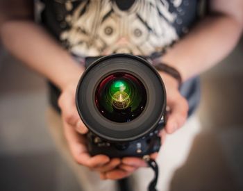 Midsection of man holding camera