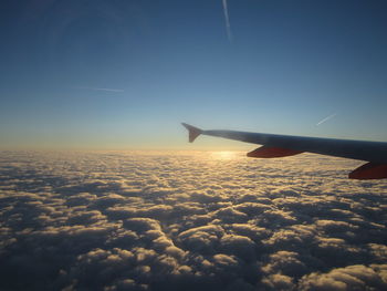 Cropped image of airplane flying over cloudscape