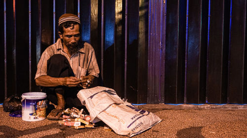 Full length of man sitting outdoors