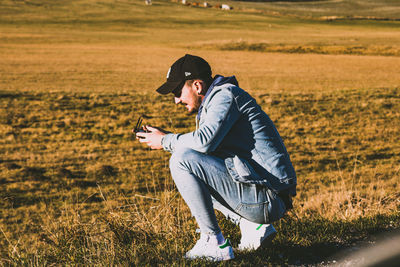 Side view of young man on field