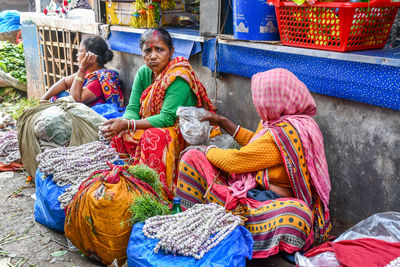 Full length of friends sitting at temple