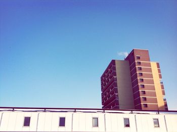 Low angle view of buildings against clear blue sky
