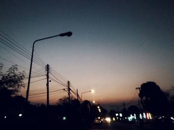 Low angle view of electricity pylon at night