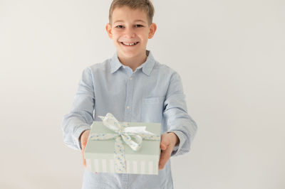 Portrait of young man standing against white background