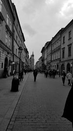 People on street amidst buildings in city