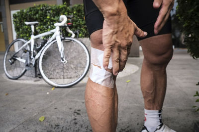 Low section of man with bicycle on street