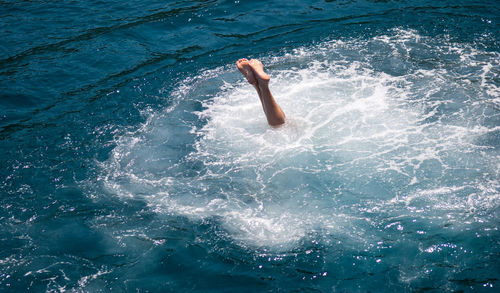Low section of person diving into water