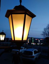 Illuminated street light against sky at sunset