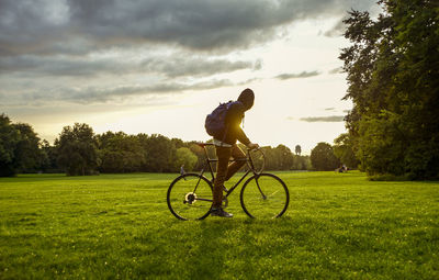 Man with bicycle on field