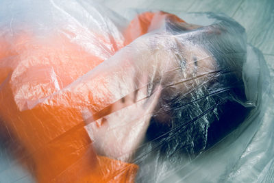 Teenage girl wrapped in plastic 