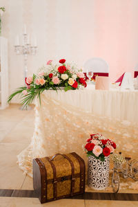 Flower vase on table against wall