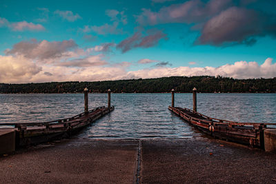 Empty pier over sea against sky