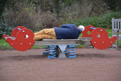 Close-up of woman sitting on wall