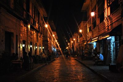 People in illuminated city at night