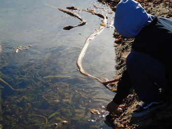 Low section of man standing by lake