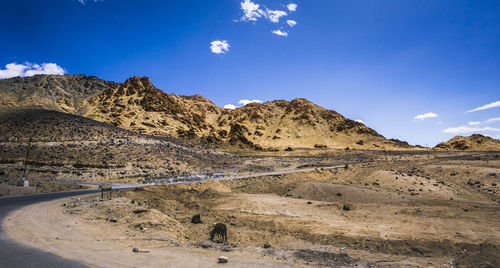 Scenic view of landscape and mountains against blue sky