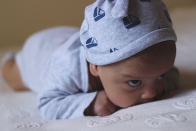 Cute baby boy lying on bed at home