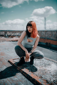 Full length of young woman sitting outdoors