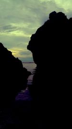 Silhouette woman by sea against sky during sunset