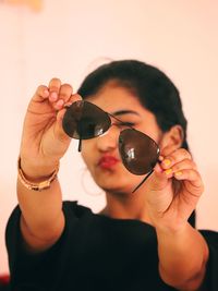 Close-up of woman holding sunglasses