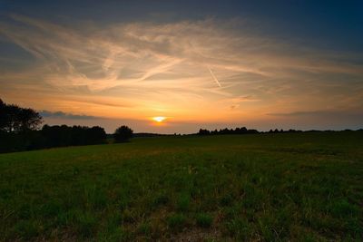 Scenic view of field against sky during sunset