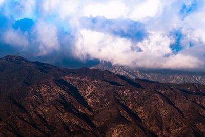 Scenic view of mountains against cloudy sky