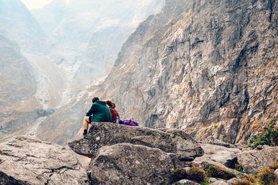 Rear view of man on rock in mountains