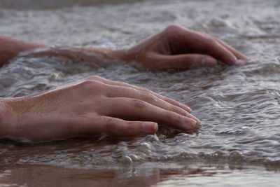 Close-up of person hand in water