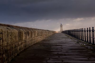 Pier over sea against sky at sunset