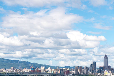 Aerial view of buildings in city against sky