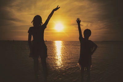 Silhouette woman standing at sunset