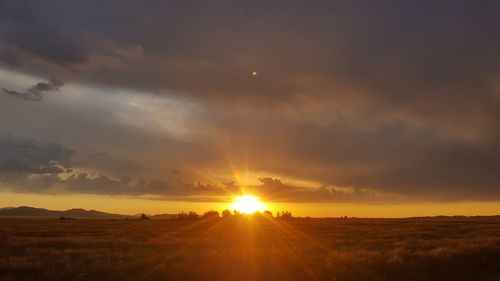 Scenic view of field against sky during sunset