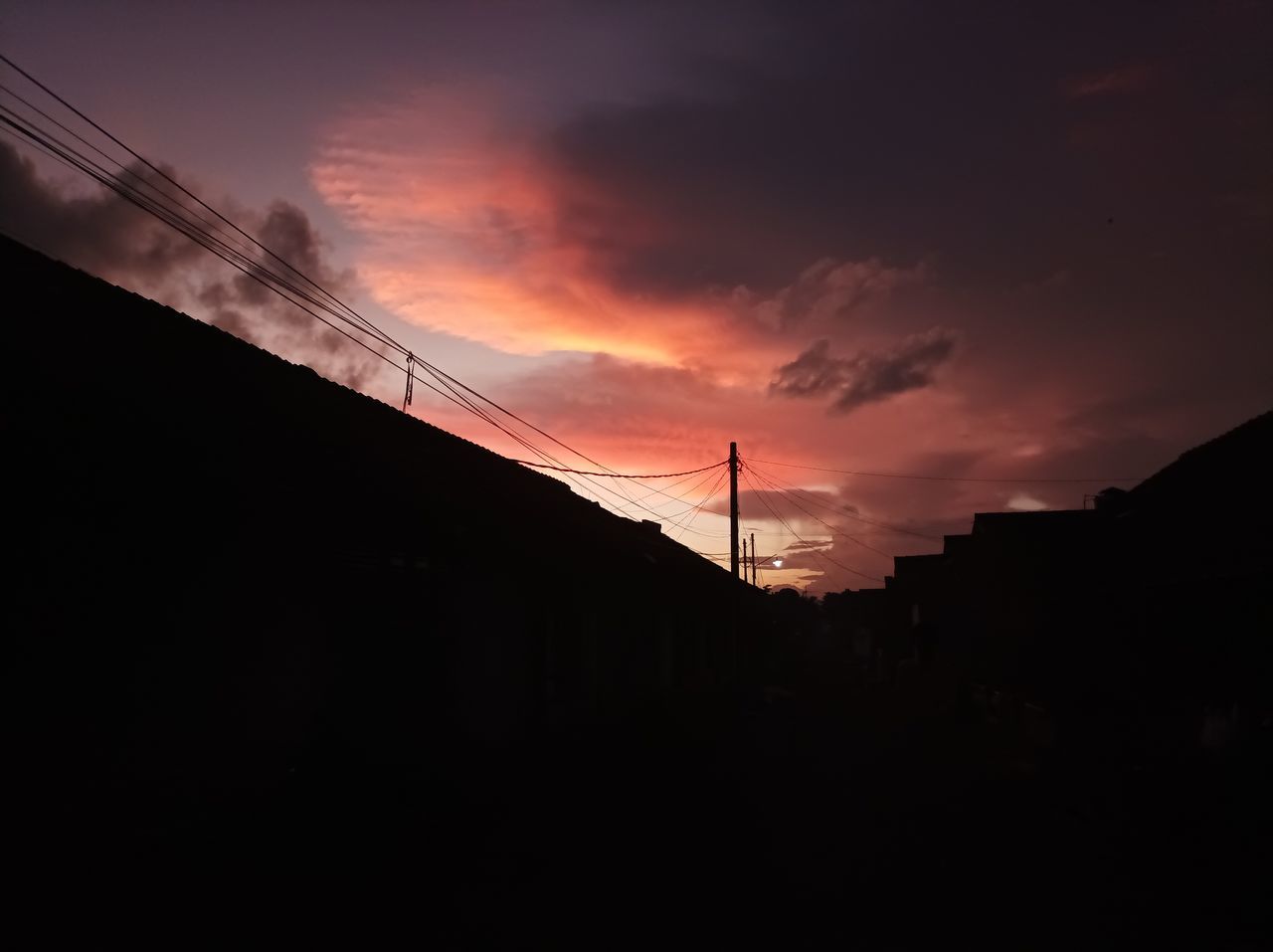 sky, silhouette, cloud, sunset, darkness, cable, electricity, sunlight, architecture, light, dawn, technology, nature, electricity pylon, built structure, evening, no people, power supply, power line, beauty in nature, afterglow, sun, low angle view, orange color, dramatic sky, outdoors, building exterior, power generation