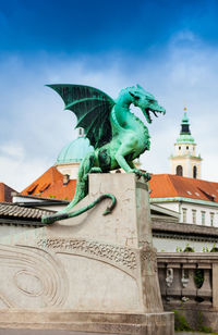 Statue of city against cloudy sky