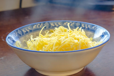Close-up of grated cheese in bowl on table