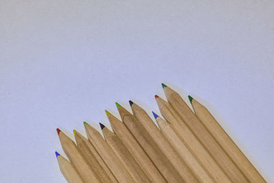 High angle view of colored pencils against white background