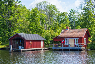 Houses and trees by lake against sky