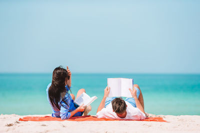 People on beach against clear sky